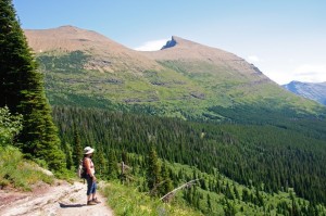 Hiker enjoying the view along the Iceberg Lake trail in Glacier National Park