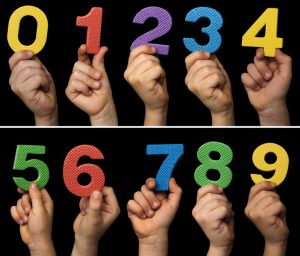 Children hands holding numbers. Black isolated multicolor numbers.