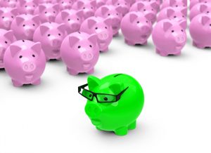 A green piggy bank standing with a group of pink piggy banks to represent the cost effectiveness of individual interviews