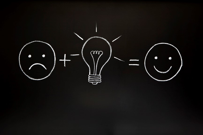 Diagram: sad face plus lightbulb equals happy face