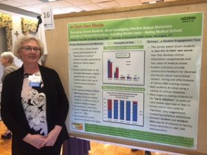 Kathleen Crea is standing next to a conference poster regarding the UConn Health Assessment in Action project.