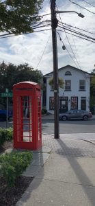 Photo of a building on the corner of an intersection with a telephone box in the foreground. 